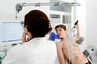 Cardiologist performs ECG,electrocardiogram on teenage boy.