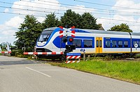 HOEVEN, THE NETHERLANDS - AUGUST 1: Train moving at high speed on a level crossing on August 1, 2016 in The Netherlands.