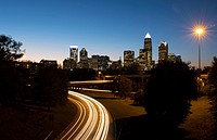 Charlotte North Carolina skyline at night with traffic blurs and twilight.