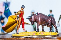 Tiny miniature vintage spanish bullfighter with bull figurine standing