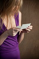Close up of a young blond woman reading a letter.