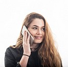 A pretty 15 year old girl speaking on smartphone looking happy in the studio against a white backdrop in the Uk.