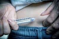 medicine diabetes glycemia health care and people concept - close up of woman with syringe making insulin injection to himself at home.