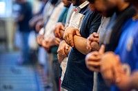 Muslim men of many ages gather for Friday afternoon prayers during religious services at an Anaheim, CA, mosque. Clasped hand position indicates Sunni...