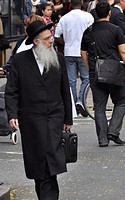 An elderly Jewish man walks down the streets of New York City