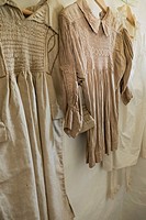 counrty smocks with traditional embroidery hung in the laundry of a Somerset cottage in England, Uk.