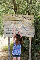 A young girl - about five years old - points on a wooden map. Signage of the River Path. Canyon de Río Lobos Natural Park. Soria. Castilla y León. Spa...