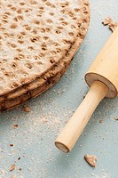 Swedish flat bread in close-up. Round crispbread and rolling pin on kitchen table.