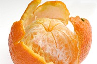 Peeled fruit with orange peel isolated on white background.