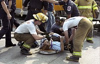 Firefighters work on a woman injured in a car accident in Glendale, Md