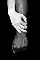 A hands of black man and white woman on black background.