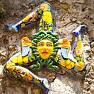 A typical ceramic Trinacria, the symbol of Sicily, hung along the streets of Taormina. Due to the islands distinct triangular shape, the symbol has al...