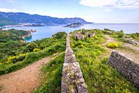 Ruins of 19th century Austrian Mogren Fortress in Budva city on the Adriatic Sea coast in Montenegro. Aerial view with Sveti Nikola Island.