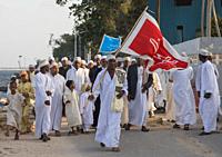 Sunni muslim people parading with flags during the Maulidi festivities in the street, Lamu County, Lamu Town, Kenya.
