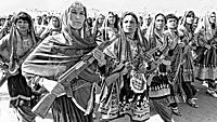 Afghan women village defense forces in traditional tribal costume carry Soviet AK-47's during a parade to mark the 10th anniversary of the communist r...