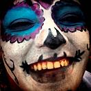 A woman paints his face as a catrina during Day of the Dead celebrations in Mexico City, Mexico