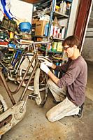 A technician restoring a vintage bicycle.