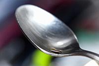 stainless steel tea spoon on a blurred multicolour background