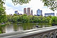 Central Park, Manhattan, New York City. Looking Over the Lake to Central Park Weet Skyline from Bow Bridge. People i Rowboats on the Lake.