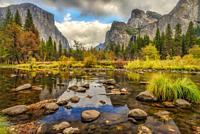 Lazy Merced River on a fall day reflects clouds over El Capitan and Bridalveil Fall of Yosemite National Park, California, USA.