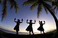 Three hula dancers at sunset at Olowalu, Maui, Hawaii.