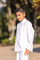 Elegant young man in white clothes posing for the camera in a photo shoot.