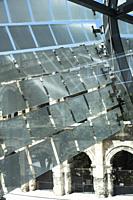 Glass and stainless steel light deflectors flutter like bunting on the facade of the Roman Museum at Nimes to reveal the massive stone arches of the R...