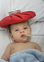 4 months old baby with thermometre and ice pack on the head