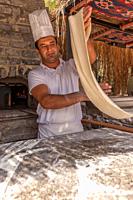Turkish pide baker baking pide for tourists at an outdoor kitchen at the beach. Near Bodrum, Turkish Riviera,Turkey,Eurasia,.