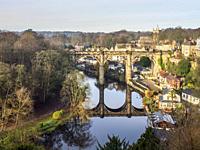 The railway viaduct reflected in the River Nidd on a sunny winter day at Knaresborough North Yorkshire England.