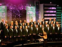 Woman conducting a traditional welsh male voice choir singning in competition for best choir in Wales.