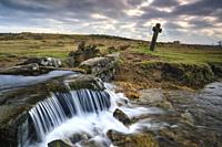 The Celtic cross and waterfall at Windy Post in the Dartmoor National Park. The image was captured on an atmospheric afternoon in mid January, using a...