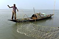 Fisherman cleaning plastics and other materials from their fishing net after fish in the Brahmaputra river in Guwahati, Assam on Tuesday, 19 February,...