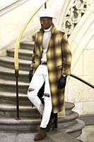 stylish wealthy man wearing expensive clothes, standing on stairs, in city Munich, Germany.