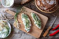 Sourdough bread with cottage cheese and wild edible plant allium vineale, or crow garlic.