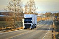 Salo, Finland - March 1, 2019: White Volvo FH truck double trailer for Posti Group, Finnish postal service on highway at sunset time in early spring.