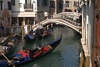 canal with three gondolas and two bridges, Venice, Italy.