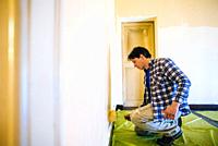 husband father of forty years, paints house wall - man painting wall of a room-man performs DIY painting at home.