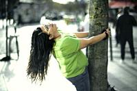 eased woman embracing tree in city, in Paris, France