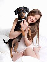 Woman in bed holding her dog.