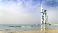 The Burj Al Arab Hotel and reflections in a sandy beach in Dubai, UAE, Middle East.