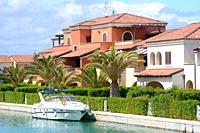 Motor yacht at houses and palm trees in Lido di Policoro, Basilicata, Italy, Mediterranean Sea, Europe.