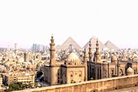 View on the Mosque-Madrassa of Sultan Hassan in Cairo and the Pyramids of Giza, Egypt.