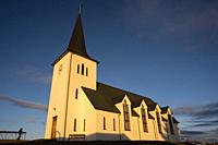 View of the church, illuminated by the sunset sun, from Borgarnes, (near Reykjavik) in Iceland. A sample of the typical traditional architecture of th...
