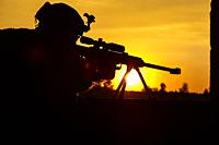 Army sniper with large-caliber sniper rifle seeking killing enemy. Silhouette on sky background. National security ensured, servicemen on guard.
