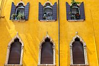 windows in the facades of ancient Venetian houses.