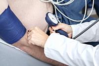 Cardiologist monitors blood pressure of patient during cardiology strees test.