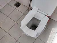 Toilet paper put on Open Toilet seat. Cover The Toilet Seat With Tissue Paper. Public toilet.