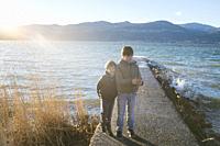 brothers children on the pier in the beach of Lake Maggiore.