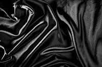 Shiny black satin pleated fabric background. Close up.